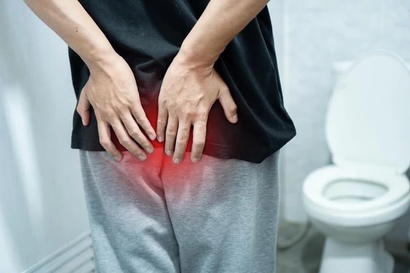 Man experiencing discomfort from piles or fissure